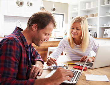 Couple doing their finances together with laptops.