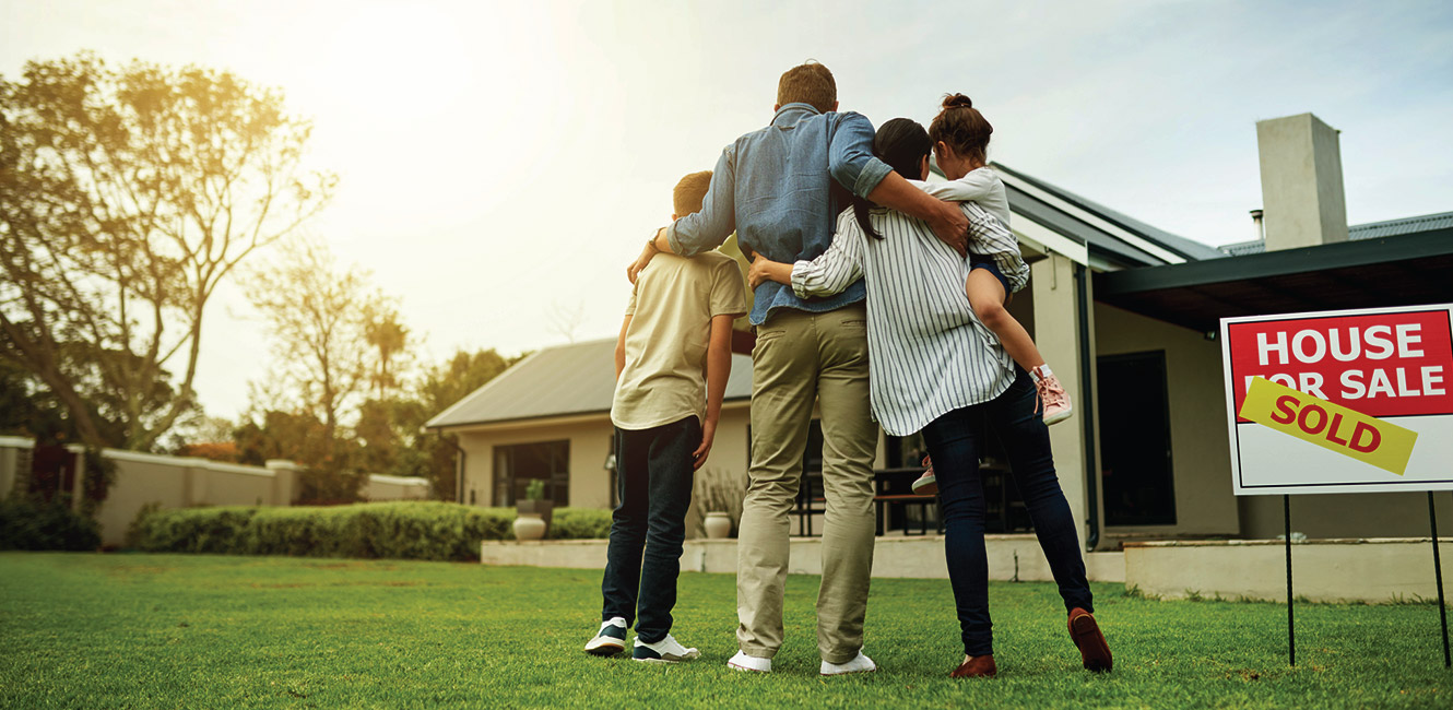 Family standing in front of newly purchased home.
