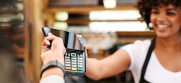 person using phone to pay from smiling woman