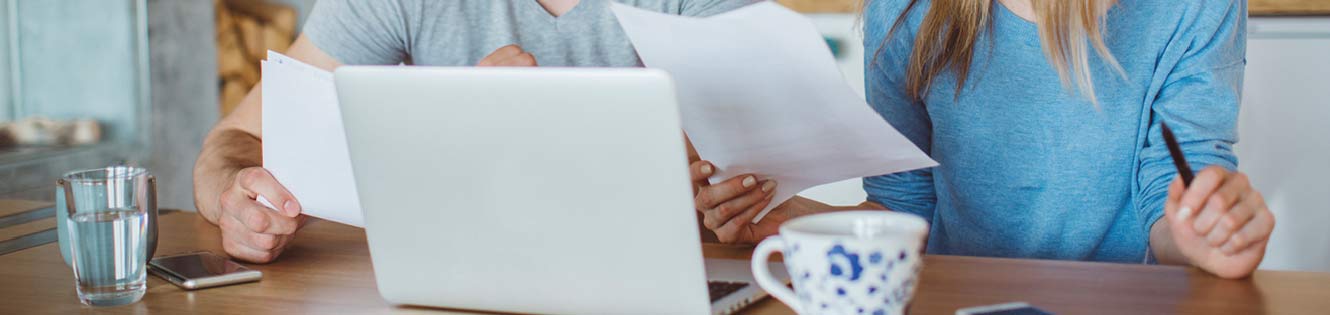 Couple sitting in front of laptop checking finances.